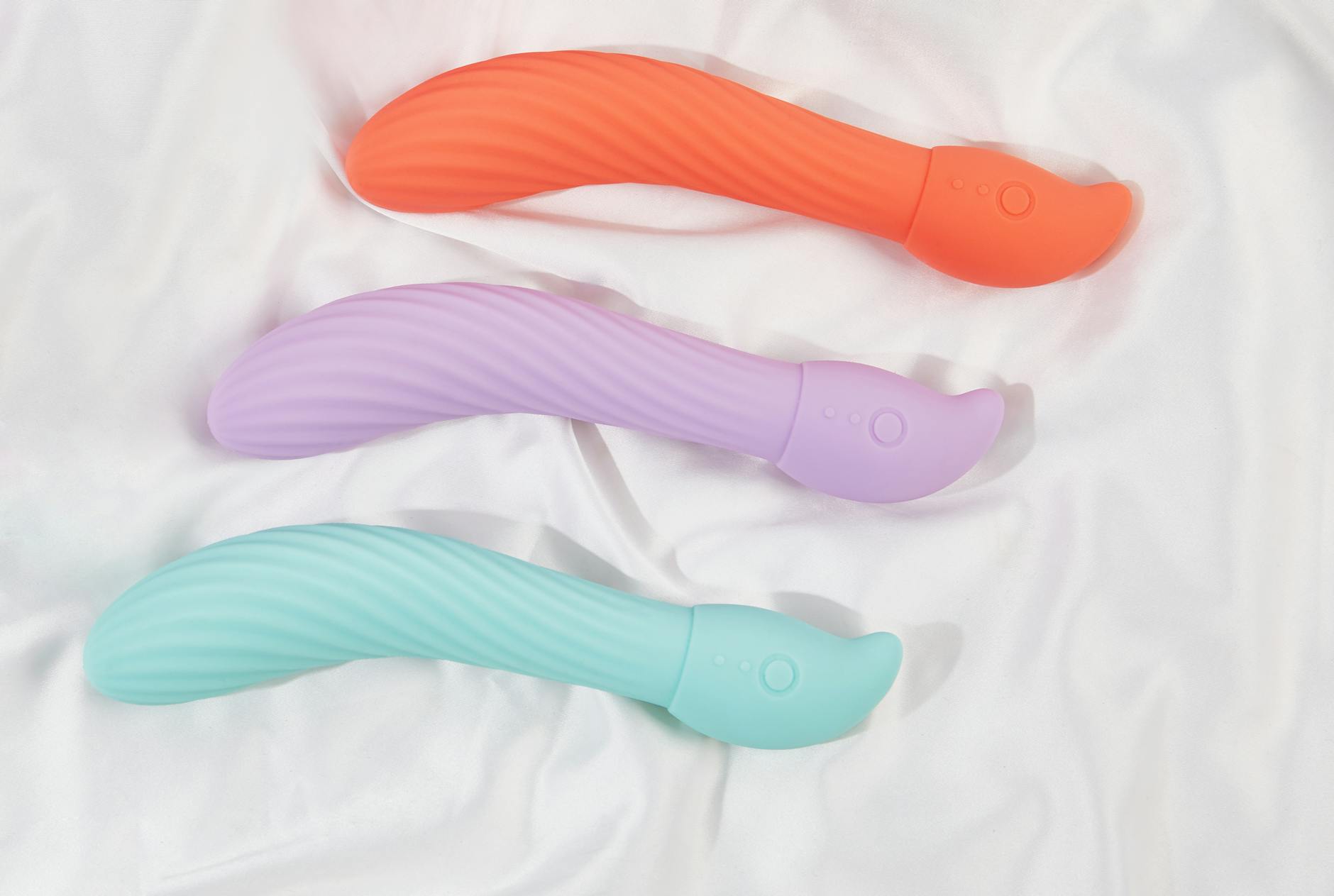 Three colorful lemon vibrators arranged on white fabric, highlighting their smooth design