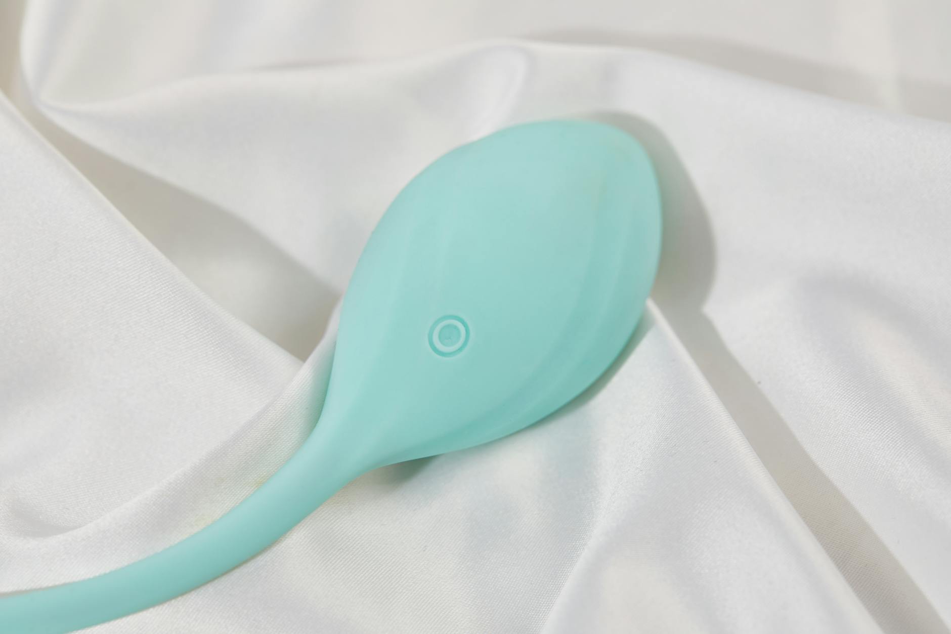 A sleek yellow vibrator on soft white silk, representing the gentle approach to lemon sexual toys for beginners