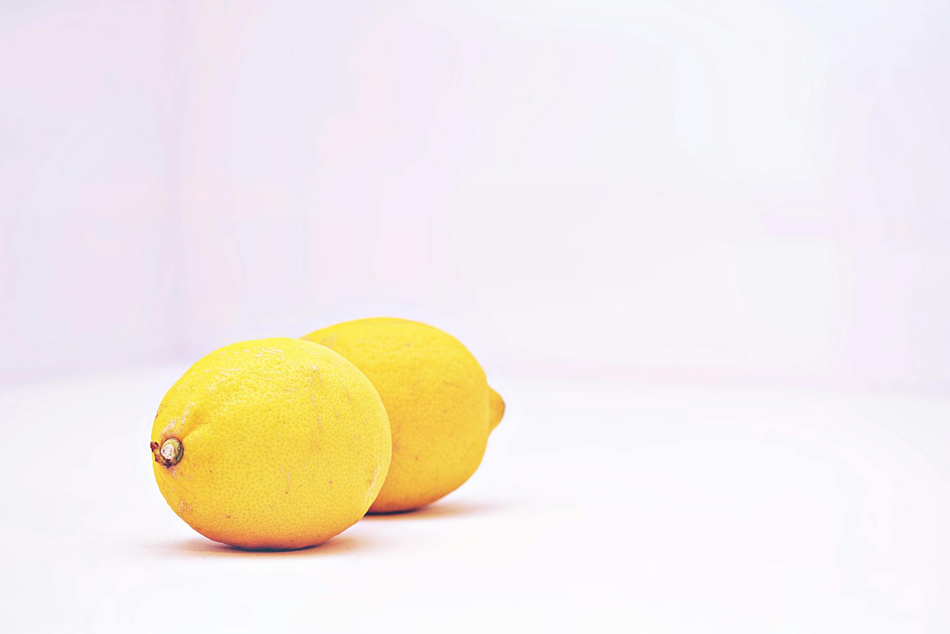 Two vibrant lemons on a white background, representing freshness and intensity control