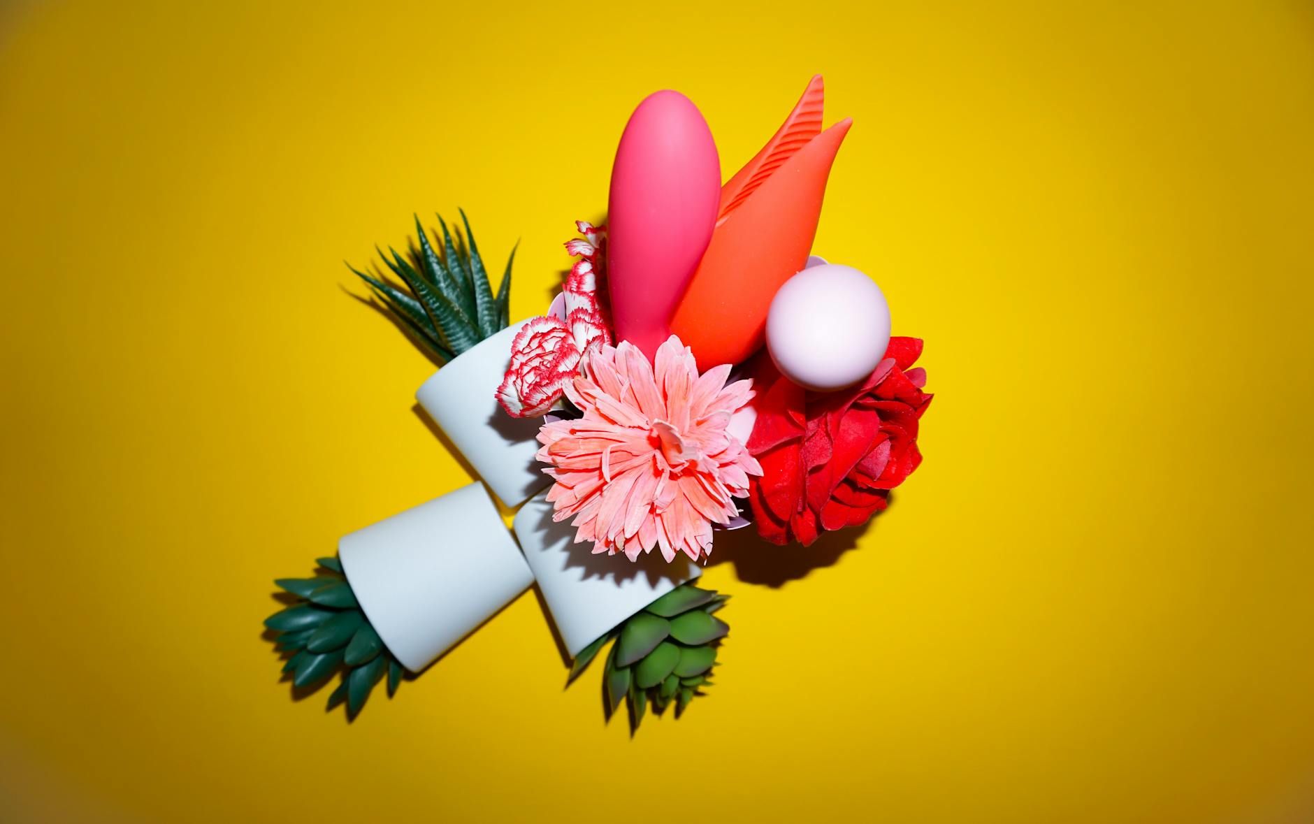 Hand reaching over a variety of colorful vibrators, representing postpartum pleasure options