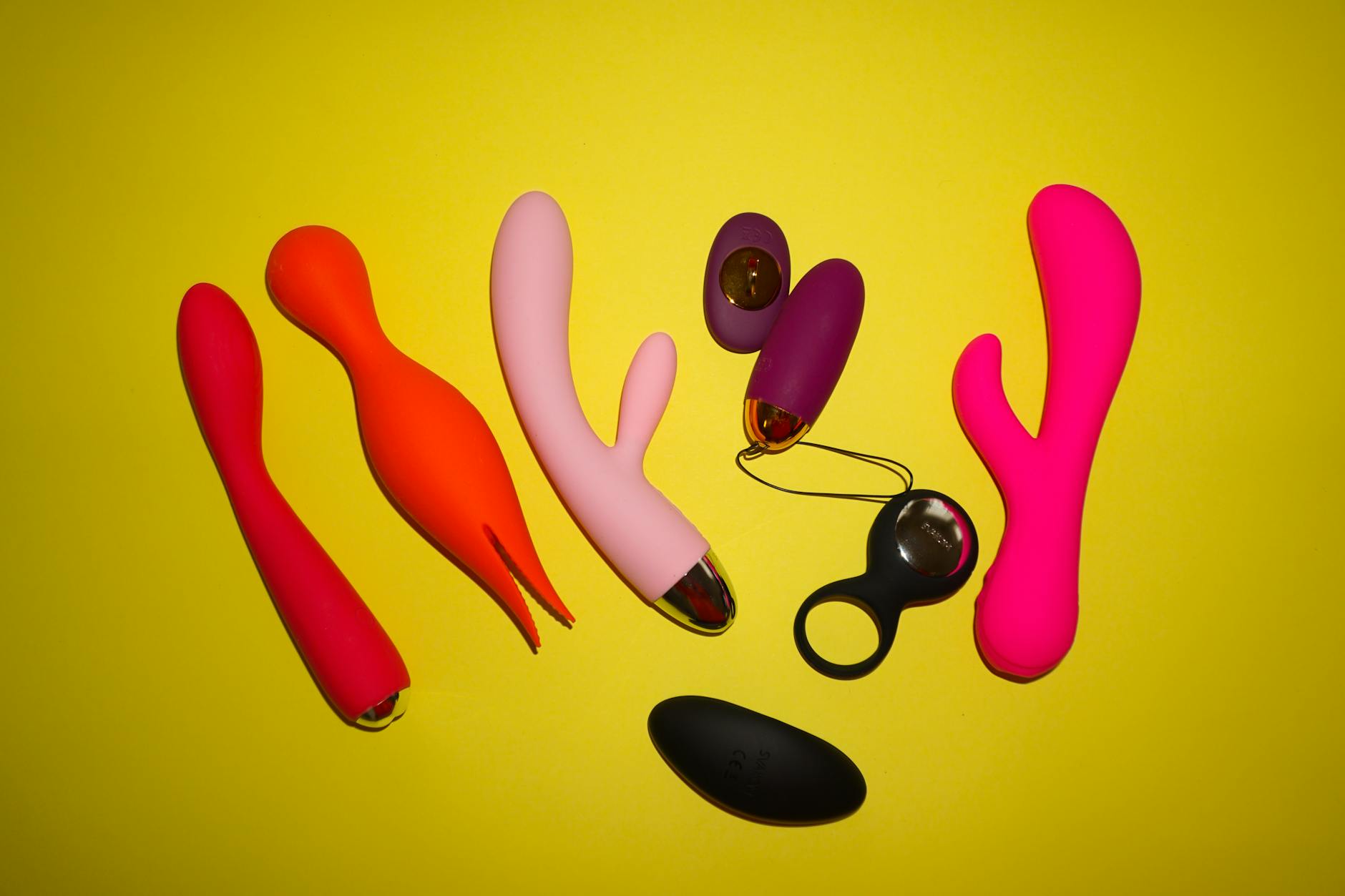 Hands holding a sleek blue vibrator against a purple background, emphasizing intimate pleasure exploration