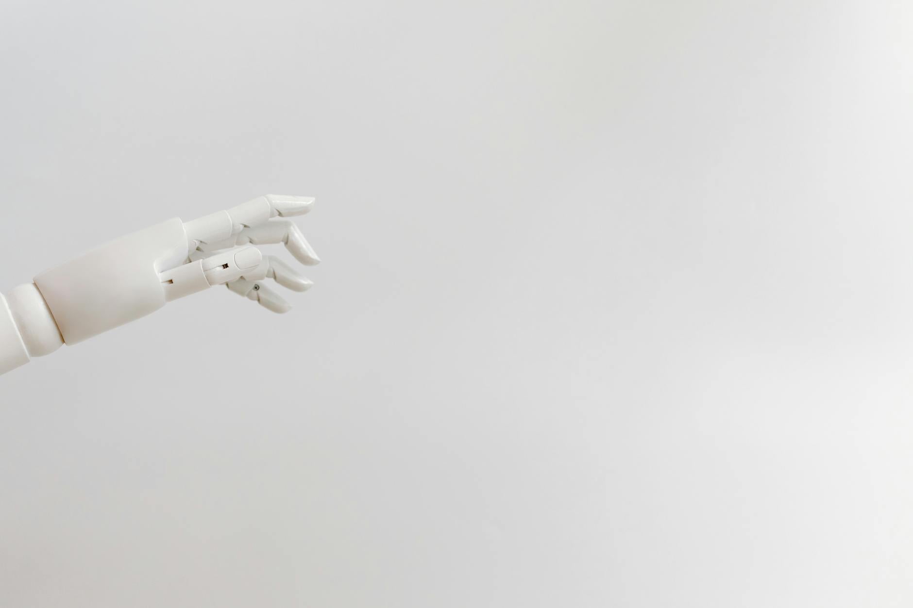 Robotic hand reaching out to a human hand against white background