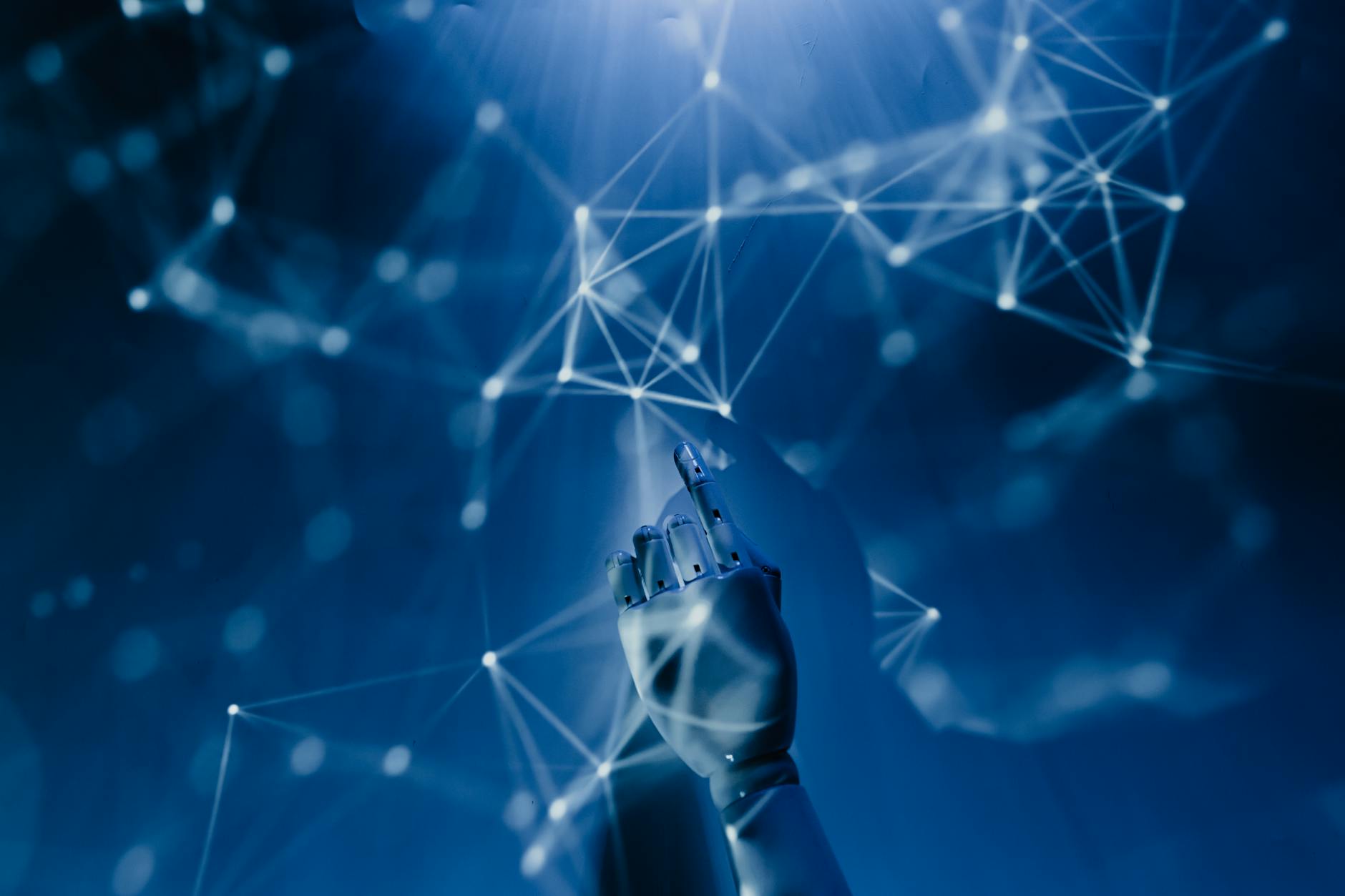A robotic hand reaching into a digital network on a blue background, symbolizing AI technology and digital connection.